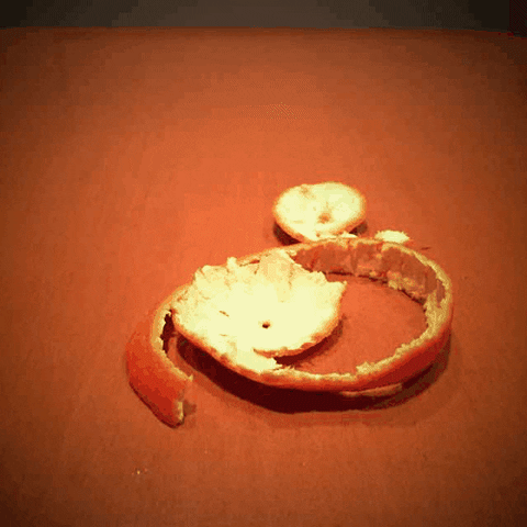 a stop motion gif of a peeling mandarin
