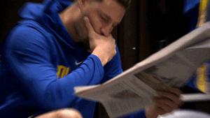 Warriors basketball player reading newspaper intently