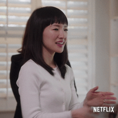 Marie Kondo putting her hands together and bowing.