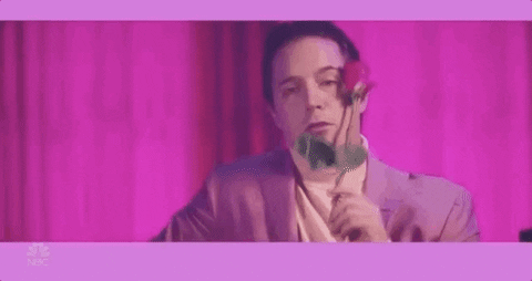 A man holding a rose and acting sexy