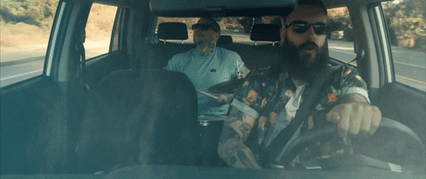 two men singing inside a moving car