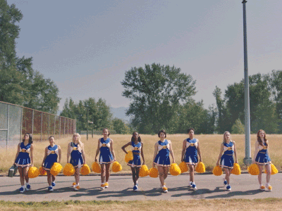 Cheerleading squad from Netflix TV show Riverdale walking towards camera with pom poms