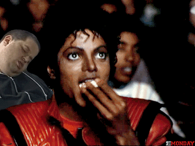 filmes que ajudam no Enem: gif do cantor Michael Jackson comendo pipoca e assistindo um filme na sala de cinema. 