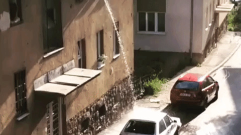 Guy washing car from his window