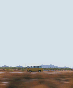 Orange VW bus traveling the desert highway.