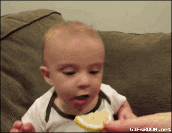 Un bébé fondant en larme après avoir croqué une tranche de citron