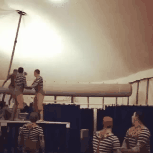 men performing trust excercise as man jumps off of platform into other mens arms