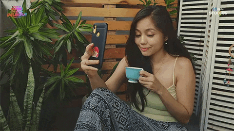 A woman sipping coffee and video calling