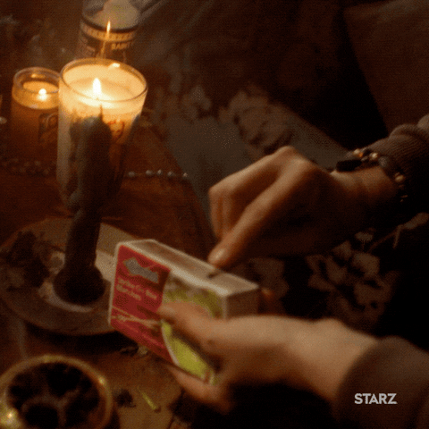 a person lighting up a candle using a matchstick
