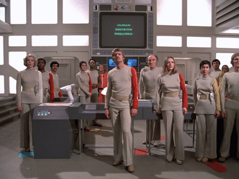 A group of sci-fi characters standing in front of a computer. GIF zooms in on computer which reads "Human Decision Required"