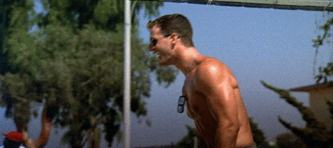 GIF of the volleyball scene from Top Gun. Iceman spins the ball on this finger. Maverick pushes up his sunglasses and huddles with Goose.