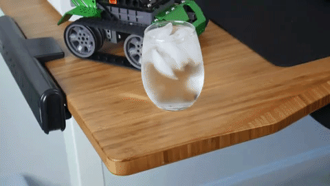 full glass of water going up on adjustable desk