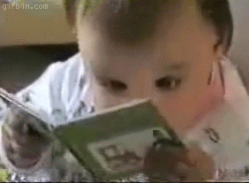 Baby intently reading a book