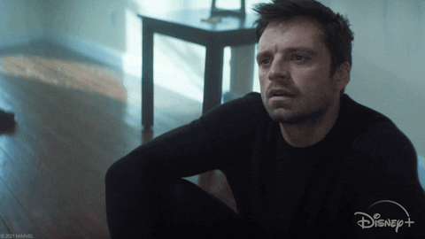 Bucky (Seb Stan) sitting cross-legged on his apartment floor, looking both hurt and angry