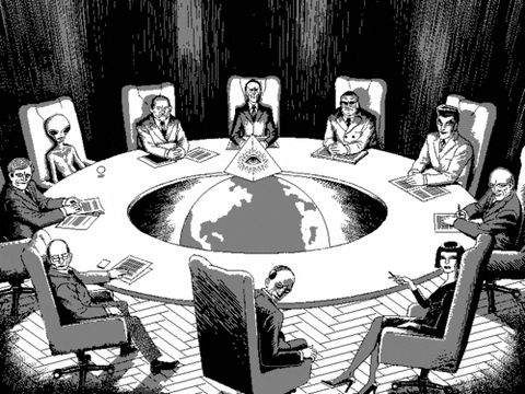GIF prikazuje skupino ljudi (in vesoljca), ki sedijo za okroglo mizo.
