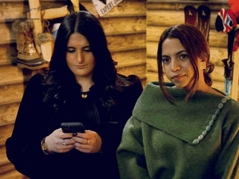 Two friends reacting to something on a phone screen