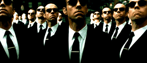 The Matrix Reloaded: a crowd of identical Agent Smiths in black suits and sunglasses stands shoulder to shoulder