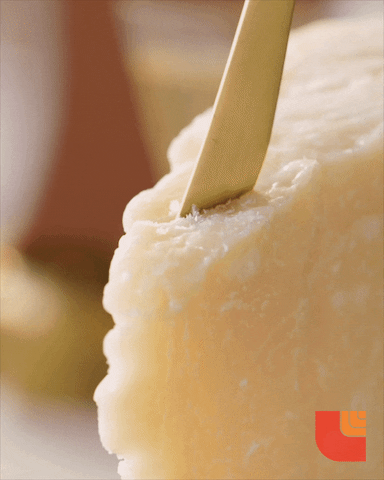A gif featuring white cheese being sliced