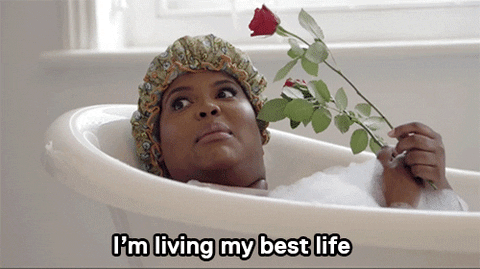 A GIF of woman in a bubble bath with a rose saying, I'm living my best life.