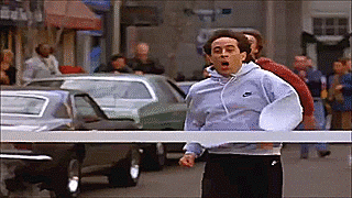 Seinfeld breaking through a finish line victoriously