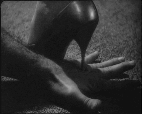 Ženski čevlji s peto pritiskajo na moško dlan 