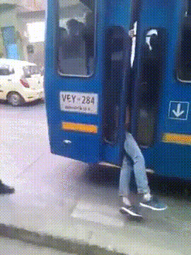 gif of a bus full of people with one guy with the legs out of the driving bus.