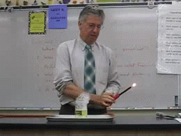 science teacher performing short fire activity in the palm of his hand