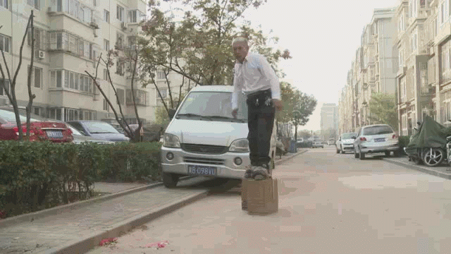 A man with concrete blocks attached to his feet flails his arms as he attempts to walk