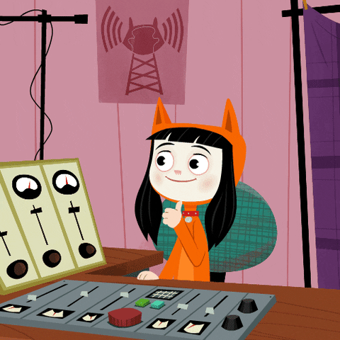 a girl in an orange cat costume gives a thumbs-up in front of a mixing board