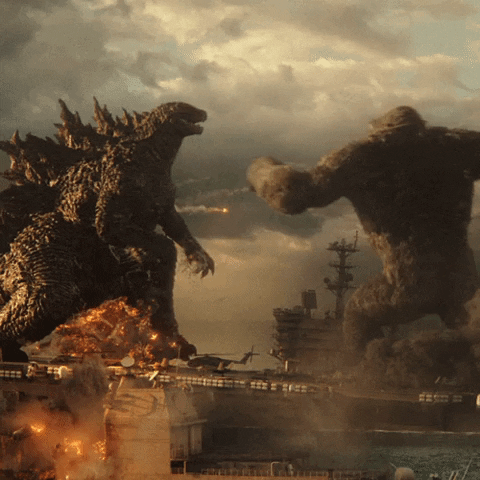 Movie gif. In a scene from Godzilla vs. Kong, Kong punches Godzilla in the face as the two title heavyweights fight on top of a battleship.