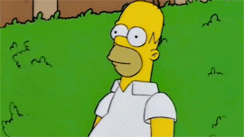 Homero Simpson escondiéndose lentamente en un arbusto 