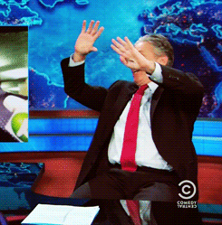 Jon Stewart putting his hands up over his face