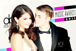 Justin Bieber giving Selena Gomez a kiss on the cheek on the red carpet.