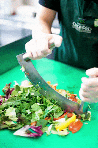 Un cocinero corta vegetales - veganismo y vegetarianismo