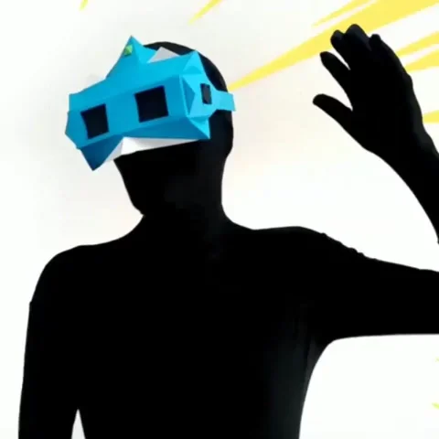 Figure in a blue geometric paper mask waving against a yellow burst