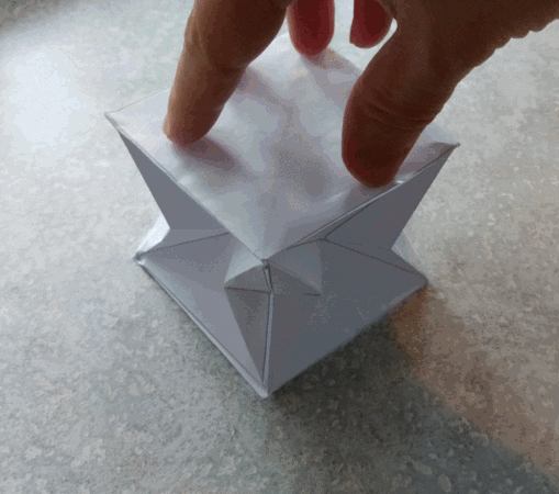 animation of paper cube being crushed