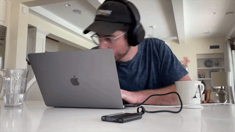 homem bebendo café enquanto edita muitos vídeos em seu notebook