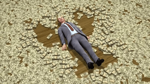 Man in suit making a snow angel in stacks of money on the floor