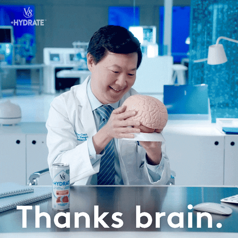 Homem de descendência coreana veste jaleco branco e segura cérebro de plástico nas mãos e beija o objeto em agradecimento. No canto inferior, é exibido o texto "thanks, brain."