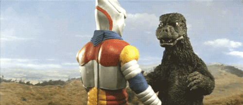 A GIF of Godzilla and Jet Jaguar shaking hands.