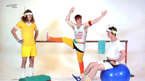 Three men in 80s workout gear use exercise equipment