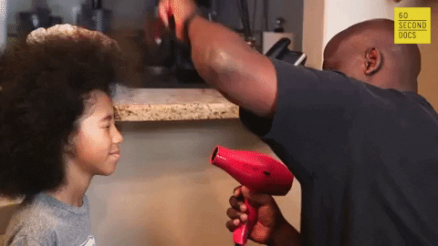 Man blowdrying young boy's hair