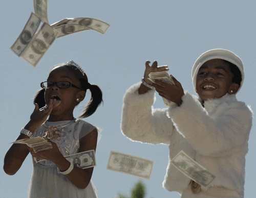Two young girls from the TV show Blackish throwing money in the air