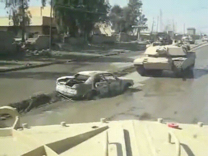 GIF: Tank v Iraqu prevozi bombo, skrito v avtu.