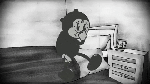 an old black and white animation of a character looking at a picture by their bedside table