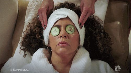 Gif of woman with cucumbers on eyes getting temple massage