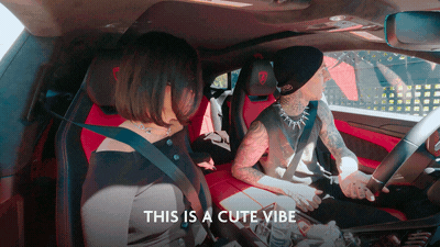 The gif of Kourtney Cardashian in the car with Travis Barker. He is driving the car, she says "This is a cute vibe".