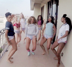 Beyoncé and a group of women standing on top of a balcony, celebrating a Quinceanera