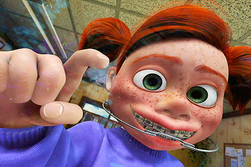 A young cartoon girl with braces, tapping the glass of a fish tank.