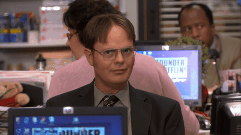 This is a GIF of Dwight from The Office placing his index finger on his lips and mouthing, "Shush."